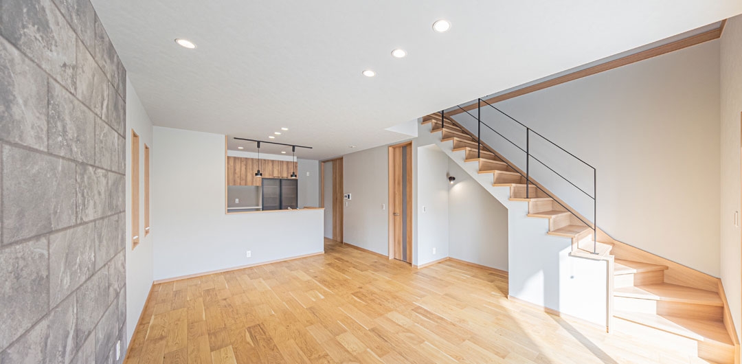 キッチンと階段が一体になったLDK全体。直線的な動線が特徴の空間。