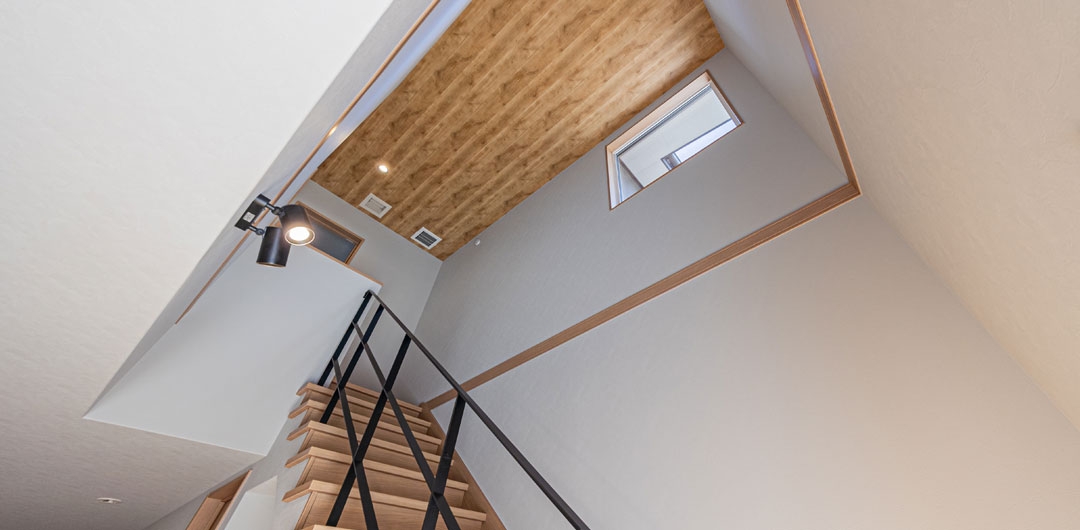 吹き抜けと階段を組み合わせた室内空間。上部の窓から光を取り込む設計。